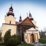 Drewniano-murowany kościół z dwoma wieżami z zewnątrz.