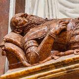 Rzeźba z marmuru leżącego mężczyzny, z długą brodą, w zbroi. Obok leży miecz, pod głową poduszka.