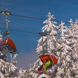Kilku narciarzy na wyciągu krzesełkowym na stacji narciarskiej Słotwiny Arena