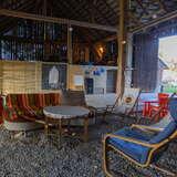Wnętrze drewnianej stodoły, kolorowe fotele, kanapa, hamak