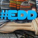 litery tworzące hasztag EDD ułożony na rękawicach furmańskich