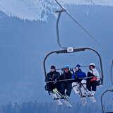 Cztery osoby na krzesełku na kolei krzesełkowej w ośrodku narciarskim Mosorny Groń w Zawoi.