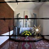Ołtarz w kaplicy widziany zza drutu kolczastego.